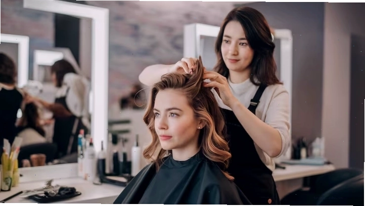 Thợ làm tóc nữ đang tạo kiểu tóc trong thẩm mỹ viện